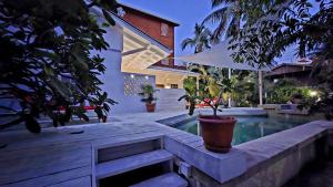 库尔克岛Amanda's Place Yellow Studio - Pool and Tropical garden的一座房子,里面设有一座带盆栽植物的游泳池