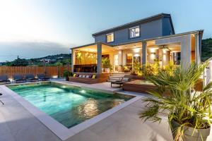 a house with a swimming pool in front of it at Private Wellness Villa on Rab - Rab Rental Villa with Pool Jacuzzi Sauna and Total Privacy in Rab