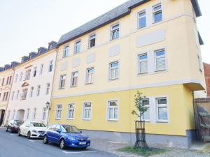 a yellow and white building with cars parked in front at Apartment in Grimma mit 2 Schlafzimmer in Grimma