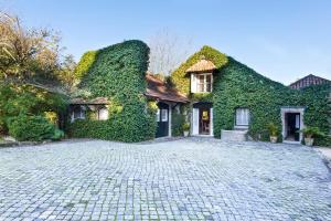 ein mit Efeu bewachsenes Haus mit einer Kopfsteinpflastereinfahrt in der Unterkunft Quinta da Penalva - Sintra in Sintra