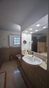 ein Badezimmer mit Waschbecken, Toilette und Spiegel in der Unterkunft Quinta da Penalva - Sintra in Sintra + 27 Fotos