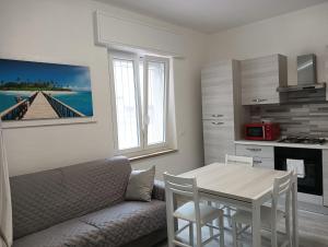 a living room with a couch and a table and a kitchen at Alassio Holidays Plus in Alassio