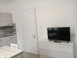 a living room with a flat screen tv on a dresser at Alassio Holidays Plus in Alassio