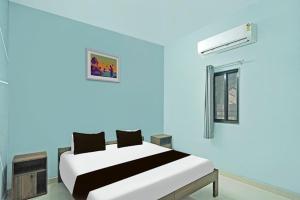 ein blaues Zimmer mit einem Bett und einem Fenster in der Unterkunft Hotel Nova in Raipur