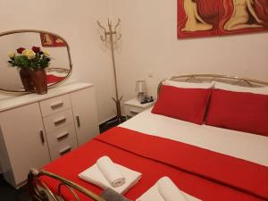 a bedroom with a red and white bed and a mirror at Tania's house in Tríkala