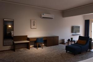 a waiting room with a desk and a tv and chairs at فندق إكليل الجبل in Ash Shafa