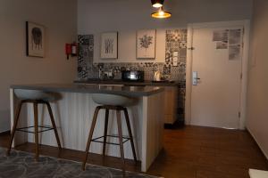a kitchen with a counter and two bar stools at فندق إكليل الجبل in Ash Shafa