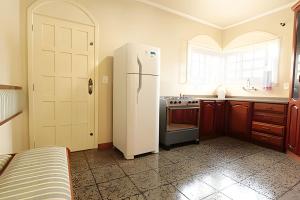 eine Küche mit einem weißen Kühlschrank und einer Spüle in der Unterkunft Rosa Casa Dália in Gramado