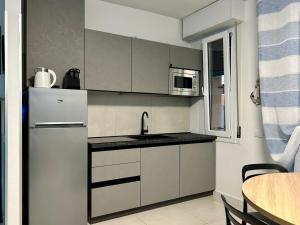 a kitchen with white cabinets and a sink and a microwave at Appartamento Conchiglia-Immobili e Soluzioni Rent in Lido Adriano