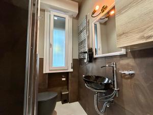 a bathroom with a sink and a toilet and a window at Appartamento Conchiglia-Immobili e Soluzioni Rent in Lido Adriano +12 photos