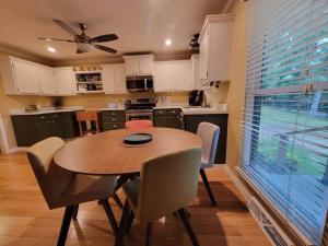 a kitchen with a wooden table and chairs and a window at My Hideaways Serinity Hill in Hardy