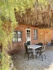 un tavolo e sedie di fronte a una casa di Tobiana Desert Lodging Negev a ‘Ezuz