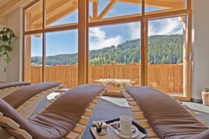 a living room with a view of a mountain at Hotel Steinrösl in San Cassiano