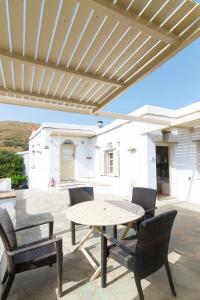 a patio with a table and chairs and a white house at Apodrasi in Stení