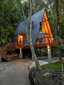 a cabin in the woods with a black roof at Rosa Cabana de Canela in Canela