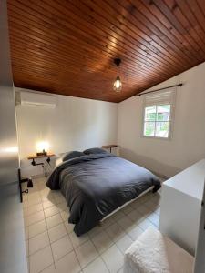 a bedroom with a large bed with a wooden ceiling at Villa Arawak,3 chambres, piscine, jacuzzi, plage in Sainte-Luce