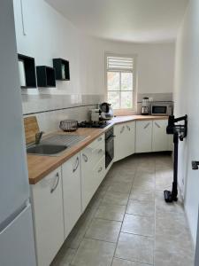 a kitchen with white cabinets and a sink at Villa Arawak,3 chambres, piscine, jacuzzi, plage in Sainte-Luce +6 photos