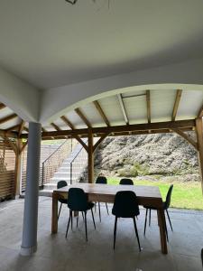 a wooden table and chairs under a pavilion at Villa Arawak,3 chambres, piscine, jacuzzi, plage in Sainte-Luce