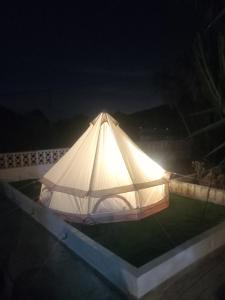 ein großes weißes Zelt, das nachts auf einer Terrasse steht in der Unterkunft Villajoyosa Yurts in Villajoyosa + 8 Fotos