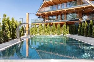 a swimming pool in front of a building at Apartamenty Bujaś Resort - Białka Spa Resort in Białka Tatrzanska