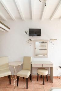 a room with a white table and chairs and a tv at Apodrasi in Stení