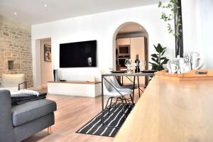 a living room with a couch and a table with chairs at Hyper Centre - Élégant Appartement au Pied des Restaurants et Boutiques in Caen