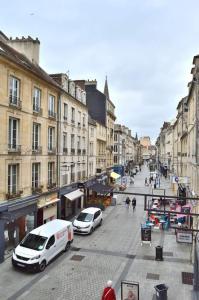 two white vans parked on a city street with buildings at Hyper Centre - Élégant Appartement au Pied des Restaurants et Boutiques in Caen
