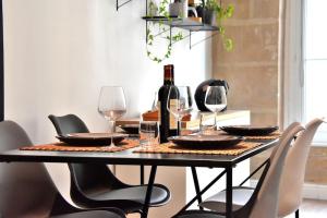 a dining room table with glasses and a bottle of wine at Hyper Centre - Élégant Appartement au Pied des Restaurants et Boutiques in Caen +13 photos