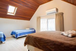 CanelaにあるRosa Casa Morar da Serraのベッド2台と窓のある寝室