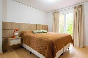 a bedroom with a large bed and a window at Rosa Casa Morar da Serra in Canela