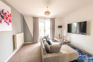 un soggiorno con un divano e una TV di Temple Wall - Contractors, Families - FREE PARKING by Prescott Apartments a Bristol