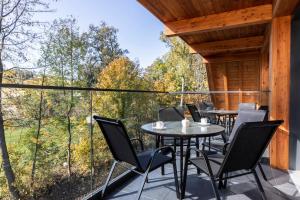 a patio with a table and chairs on a balcony at Apartamenty Bujaś Resort - Białka Spa Resort in Białka Tatrzanska