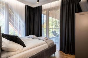 a bedroom with a bed and a large window at Apartamenty Bujaś Resort - Białka Spa Resort in Białka Tatrzanska +118 photos