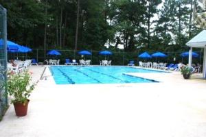 - une piscine avec des chaises et des parasols bleus dans l'établissement Cozy Cottage in Bethany Beach, Delaware, à Frankford
