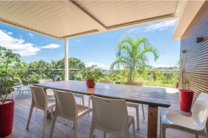 una mesa de comedor y sillas en una terraza con vistas en Villa Te Amo, en Goyave 31 fotos más