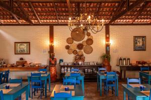 a dining room with blue tables and a chandelier at Pousada Rancho do Ralf in Pirenópolis
