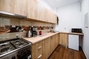 a kitchen with wooden cabinets and a stove top oven at Zen Studio 2 with balcony in Bucharest