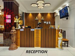 a man sitting at a reception desk in a lobby at Hotel Mandi Heights - Bar, Fine Dining & Banquet Hall in Mandi