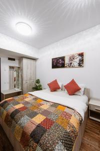 a bedroom with a bed with a colorful quilt on it at Zen Studio 2 with balcony in Bucharest +42 photos