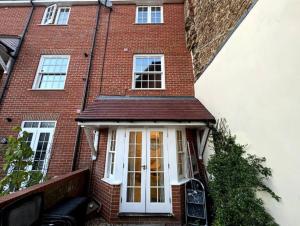 a red brick house with a white door at Queen Anne Court with FREE PARKING By Prescott Apartments in Abingdon