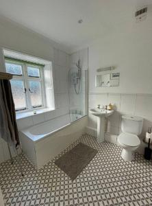 a bathroom with a tub and a toilet and a sink at Queen Anne Court with FREE PARKING By Prescott Apartments in Abingdon
