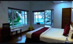 Un dormitorio con una cama con vista al mar. en White Shell Beach House, en Kannur
