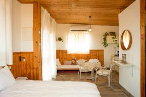 a bedroom with a bed and a table and chairs at Tobiana Desert Lodging Negev in ‘Ezuz +34 photos