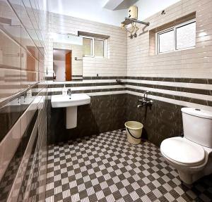 un baño con inodoro y lavabo en White Shell Beach House, en Kannur