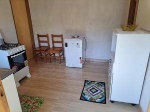 a kitchen with a refrigerator and a table and chairs at Chale da Wal in Camanducaia