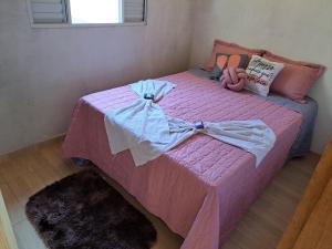 a pink bed with a doll on top of it at Chale da Wal in Camanducaia