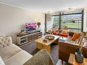 a living room with two couches and a tv at Depto nuevo 5 estrellas, ubicación insuperable in Puerto Varas