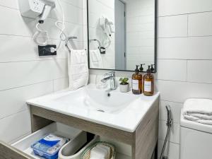 a white bathroom with a sink and a mirror at Depto nuevo 5 estrellas, ubicación insuperable in Puerto Varas +42 photos