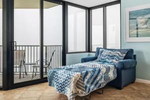 a bedroom with a blue chair and a bed at Ocean Front Beach Condo in Panama City Beach +19 photos