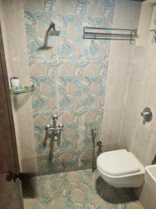 a bathroom with a shower with a toilet in it at Sunny Smiles Homestay in Mangalore +17 photos